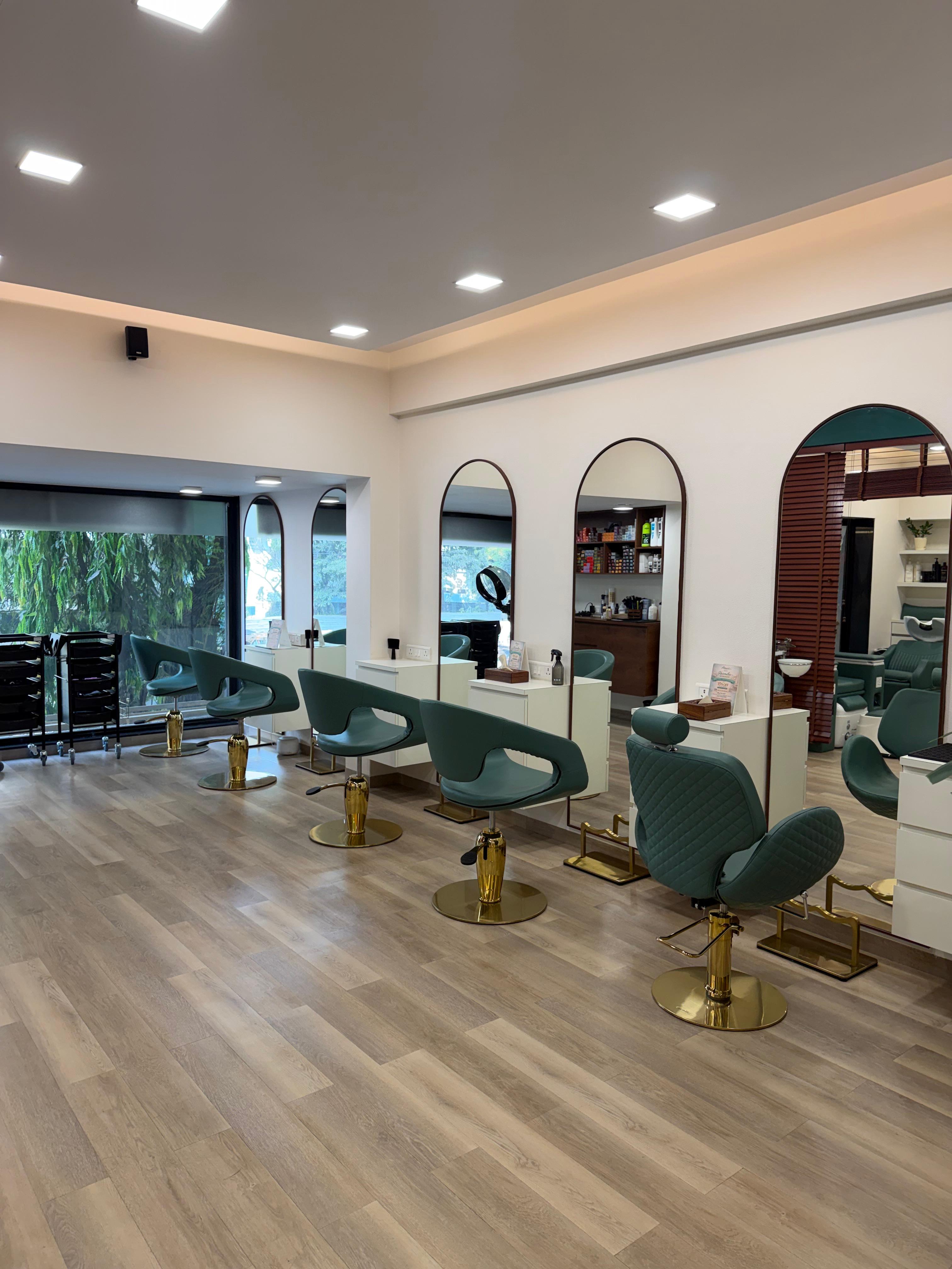 Amavi Salon interior — emerald styling chairs with gold pedestals and arch mirrors, Juhu Mumbai